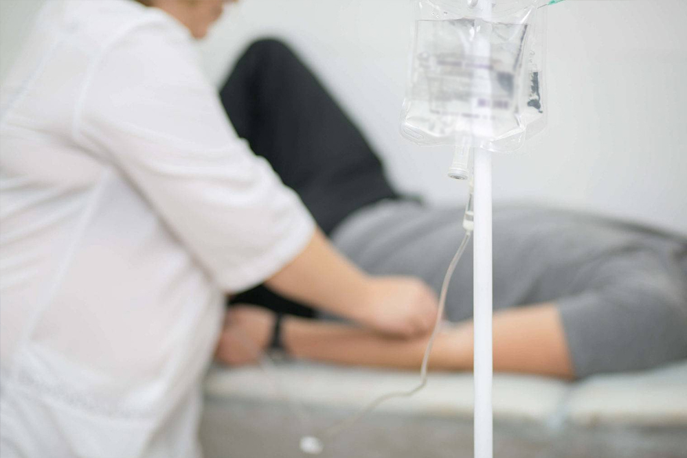 Человек лежит на кушетке и капается капельницей после запоя. Брик. Николаев