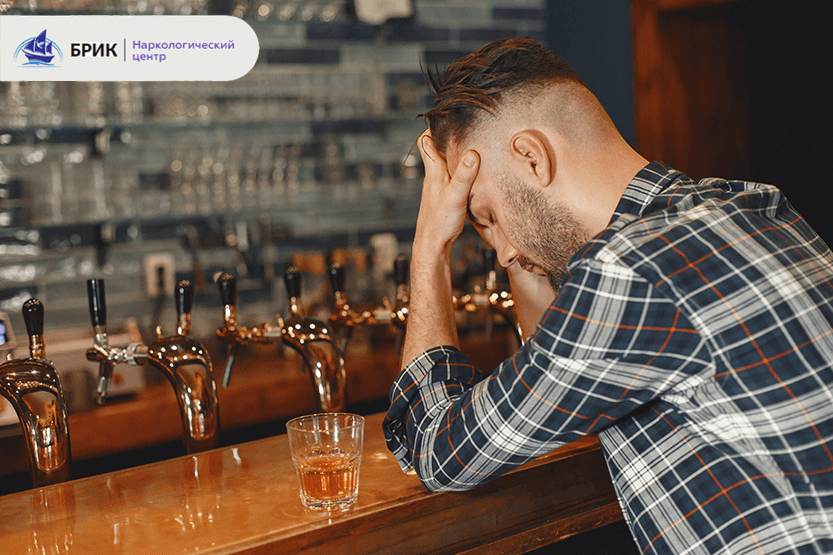 Чоловік із ознаками алкогольної залежності в барі, тримається за голову