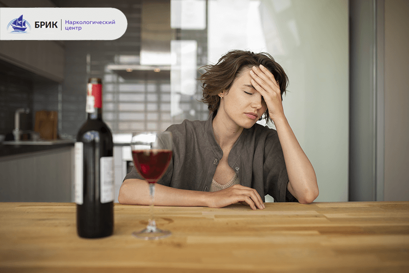 Жінка з келихом вина вдома, втомлений вираз обличчя, симптоми зловживання алкоголем